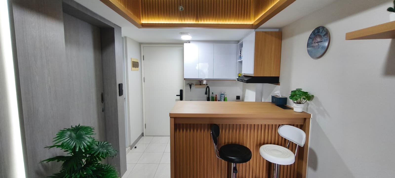 Living room keluarga — sofa besar, bookshelves built-in